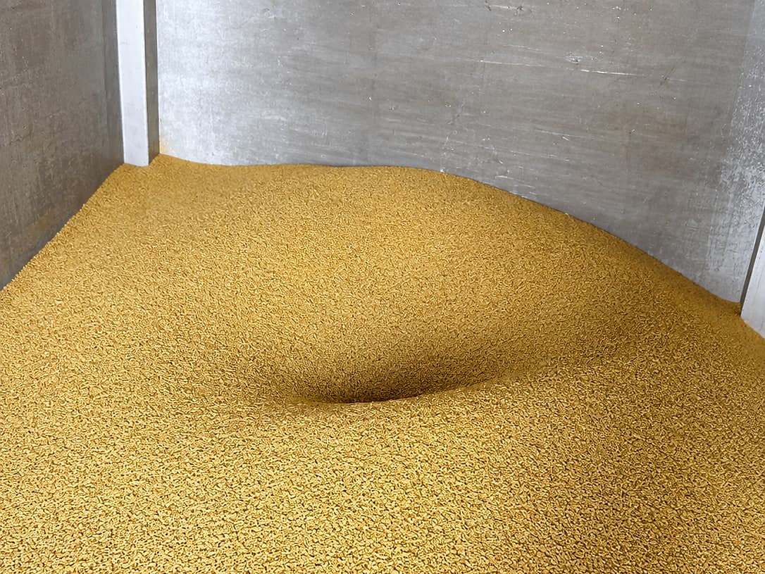 Guar meal korma held in bulk against a concrete bay wall